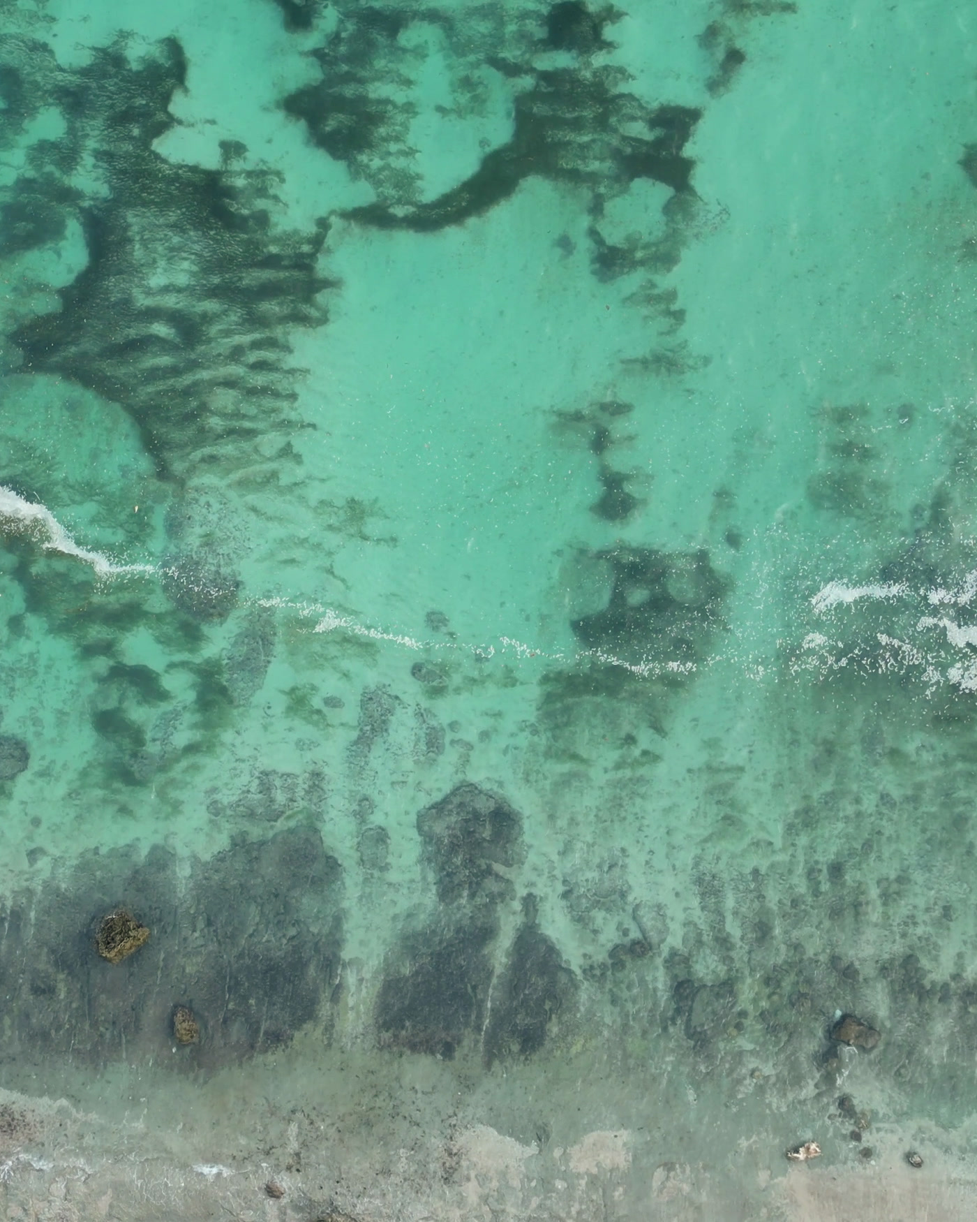 Aerial view of shallow reef and surf in the Maldives